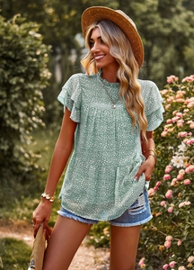 Close-up of mint green floral top with layered ruffle sleeves and delicate white print