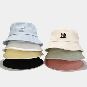 Detail of colorful cotton bucket hats with #bb atx embroidery and parallel stitching
