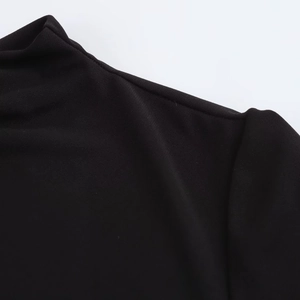 Close-up of the elegant high collar and fine knit texture on the black bodycon dress