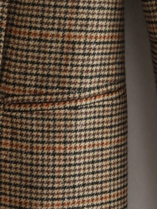Gros plan sur la texture en tweed pied-de-poule marron d'un blazer long pour femme