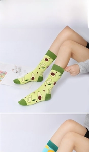 Detail of knitted crew socks with avocado and orange fruit patterns in soft cotton
