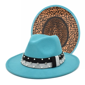 Macro detail of teal fedora hat showing pearl ribbon and leopard print underbrim