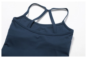 Detail of navy blue yoga top featuring cross back straps and seamless stitching finish