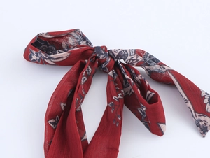 Détail du ruban en mousseline rouge à imprimé floral et motifs ethniques