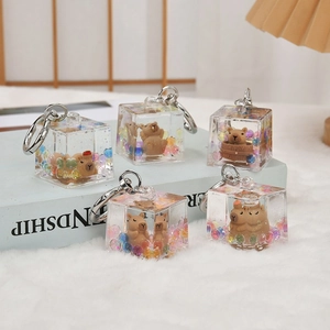 Close-up of five cute capybara resin cubes with colorful beads and metal keychains