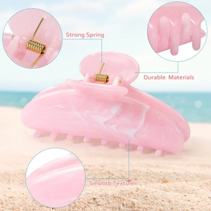 Pink marble texture hair claw clip with strong metal spring shown on a sunny beach background