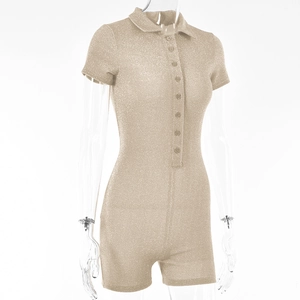 Detail view of champagne gold glitter fabric texture on a short-sleeved romper with buttons
