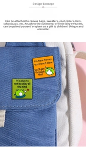 Close-up of cute cartoon frog enamel pins with inspirational quotes on a canvas bag