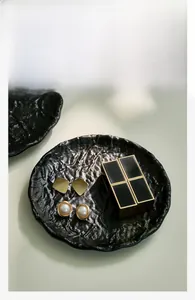 Macro detail of black hammered texture metal tray with elegant rippled finish surface