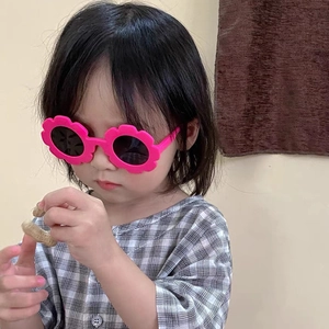 Pink flower shaped round sunglasses for kids featuring dark lenses and plastic frames
