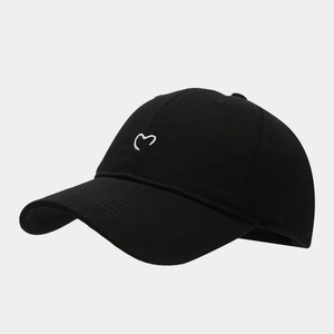Detail of white heart embroidery on a black cotton twill baseball cap with curved brim