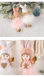 Close-up of plush Christmas angel ornaments with rabbit ears and golden wings decor