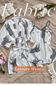 Detailed flat lay of satin leopard print pajama set with vintage props and soft lighting