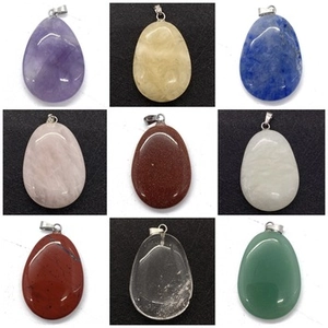 Detailed grid of assorted teardrop-shaped natural stone pendants with metal bails