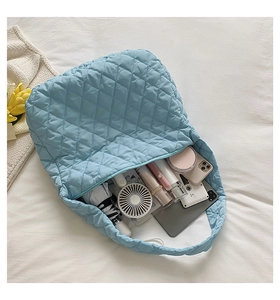 Top view of blue quilted nylon cloud bag showing spacious interior with daily essentials