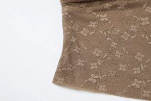 Gros plan sur un tissu en dentelle florale marron avec texture de maille détaillée