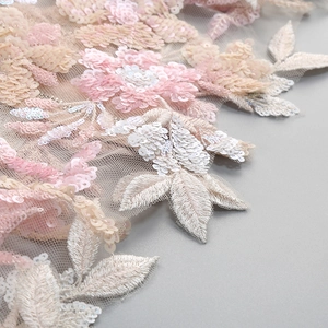 Detail of 3D embroidered floral lace with pink and white sequins on sheer mesh fabric