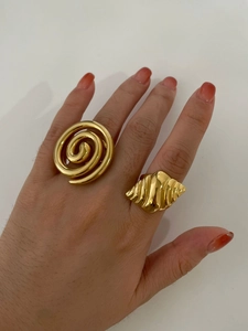 Detail of model wearing spiral conch and geometric gold stainless steel rings