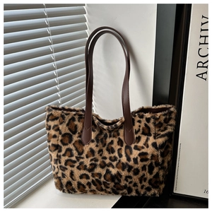 Close-up of leopard print plush tote bag with brown leather handles for autumn