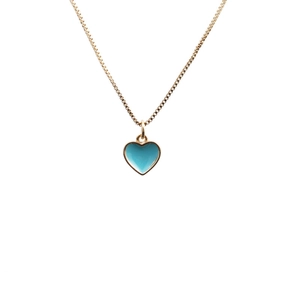 Close-up of golden box chain with blue enamel heart pendant on white background