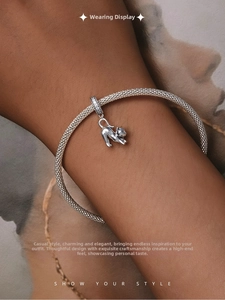 Nahaufnahme eines S925 Sterlingsilber Katzenanhängers an einem Mesh-Armband am Handgelenk