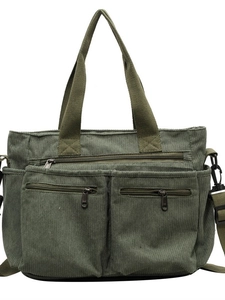 Green corduroy shoulder bag with double front zip pockets and adjustable strap
