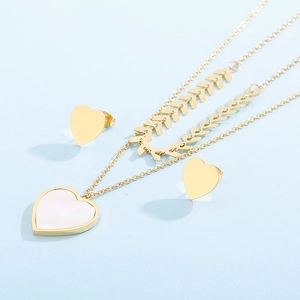 Detail of double-layer gold chain necklace with white shell heart pendant and stud earrings