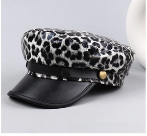 Detail of leopard print flat cap with rivet leather strap and vintage gold button