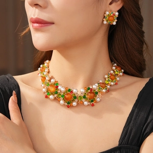 Détail d'un ensemble de bijoux vintage avec perles et gemmes colorées sur modèle