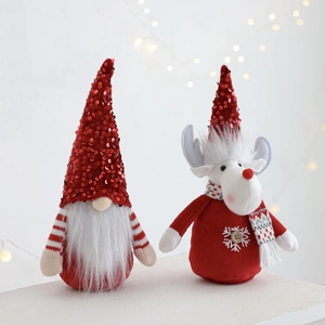 Close-up of plush Christmas gnome and reindeer dolls with red sequins and white beards