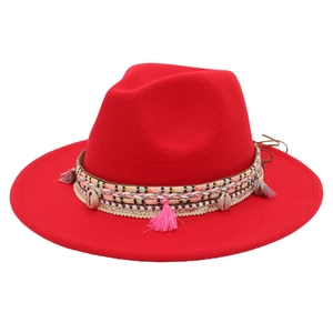 Detail of red wool felt fedora with ethnic woven band, shells and pink tassels