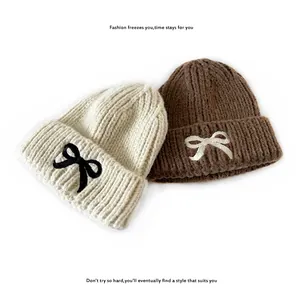 Kids knitted beanie hats with candy-colored bow embroidery in cream and brown