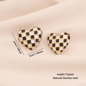 Detail showing checkered heart earrings in gold finish with size and weight specs