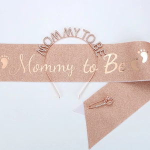 Detailed view of rose gold Mommy to Be tiara headband, glitter sash, and crown pin