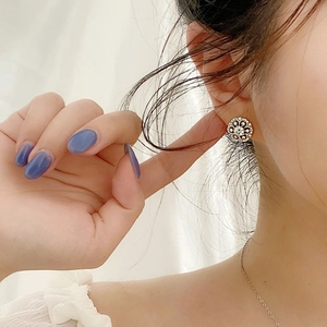 Elegant 925 sterling silver floral stud earrings with sparkling cubic zirconia on model