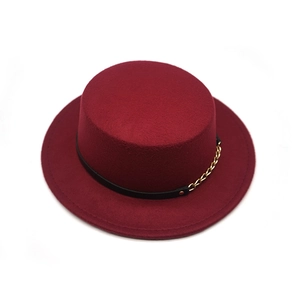 Detail of dark red felt boater hat featuring a black leather band and gold chain