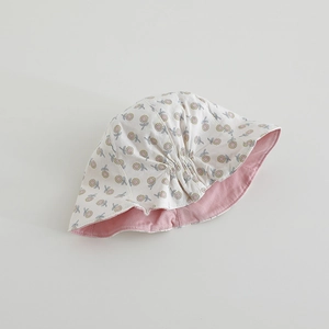 Detailed texture of baby reversible sun hat with yellow floral print and pink lining