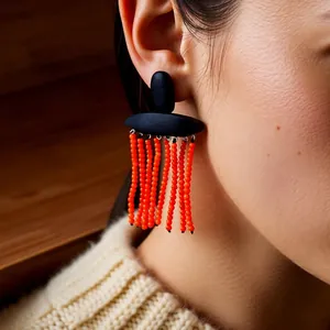 Ethnic wood bead tassel earrings with black matte finish and vibrant orange beaded fringe