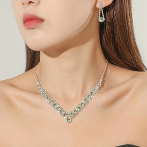 Silver bridal jewelry set featuring green gemstone necklace and earrings with rhinestones