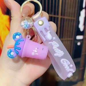 Detail of purple ice cream tea cup keychain with Pretty Good silicone wrist strap