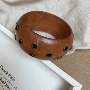 Vue rapprochée du bracelet en bois rétro avec rivets métalliques et grain naturel