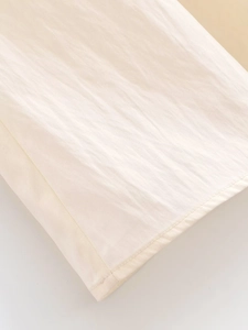 Close-up of premium cream fabric showing high-quality hem stitching and natural texture
