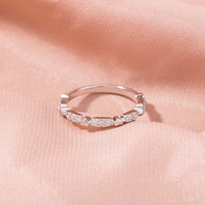 Detailed macro view of silver ring featuring heart shapes and micro-inlaid zircon stones