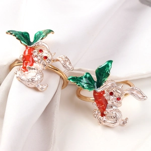 Detail of bunny and carrot napkin rings with enamel finish and red gemstone eyes