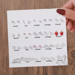 Gros plan de boucles d'oreilles perles et pompons sur carte aux styles variés