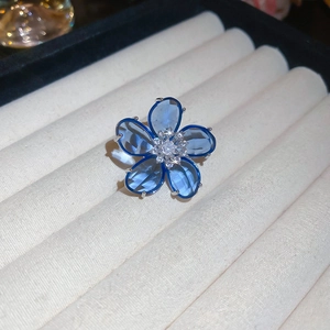Close-up of blue crystal flower ear cuff with zircon center in a jewelry display box