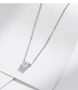 Détail macro du pendentif en moissanite étincelante avec chaîne en argent sur fond blanc