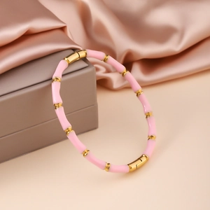 Detailaufnahme des rosa-goldenen Armreifs mit Bambusstruktur und Metallverschluss