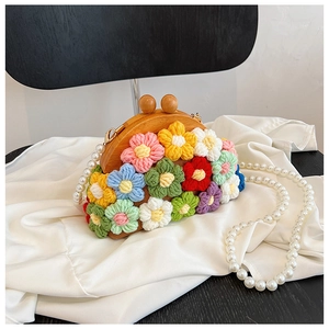 Detailed close-up of colorful crochet flowers and wooden clasp on a shell bag