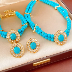 Détail d'une parure vintage en perles de turquoise avec fermoirs dorés dans son écrin